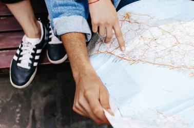 Hands of young couple on touristic map 
